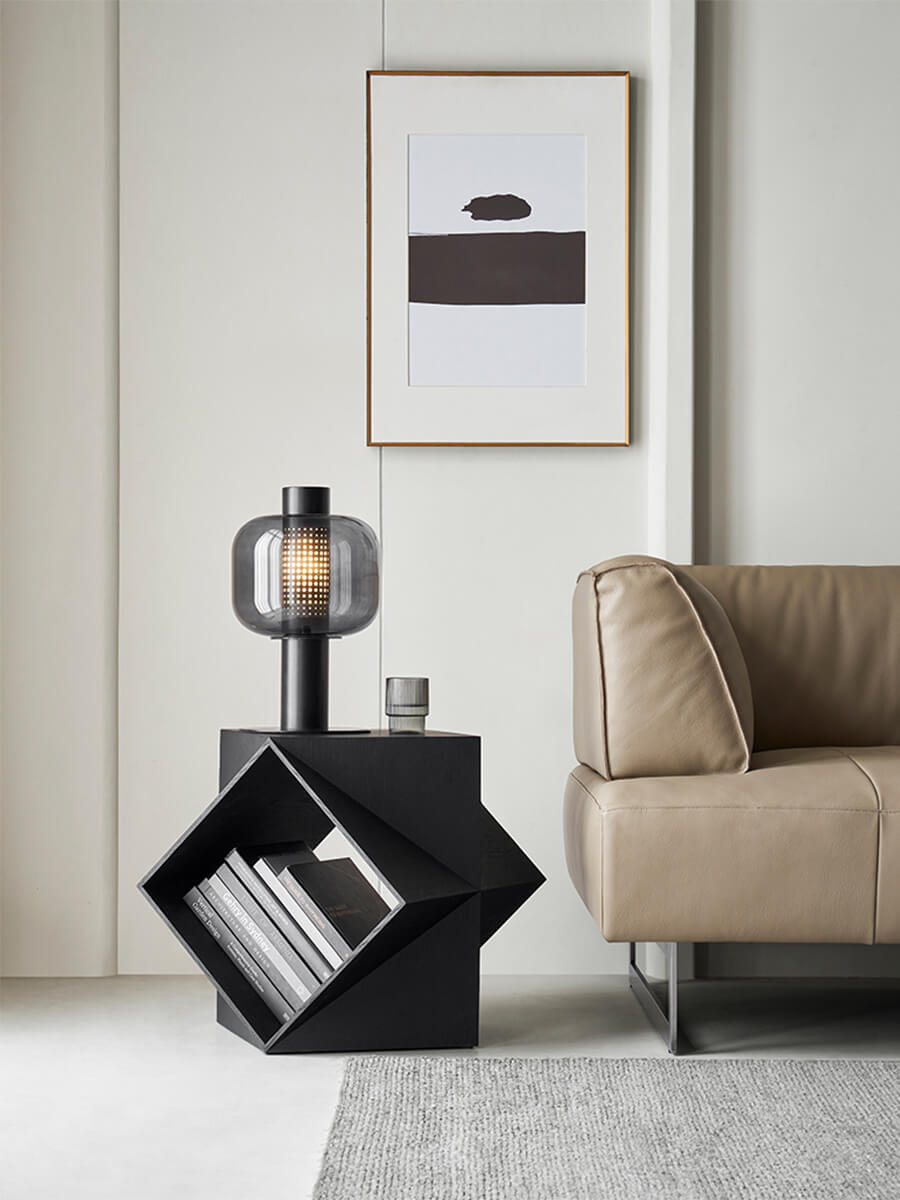 Prism Sculptural Side Table in black finish beside a modern sofa