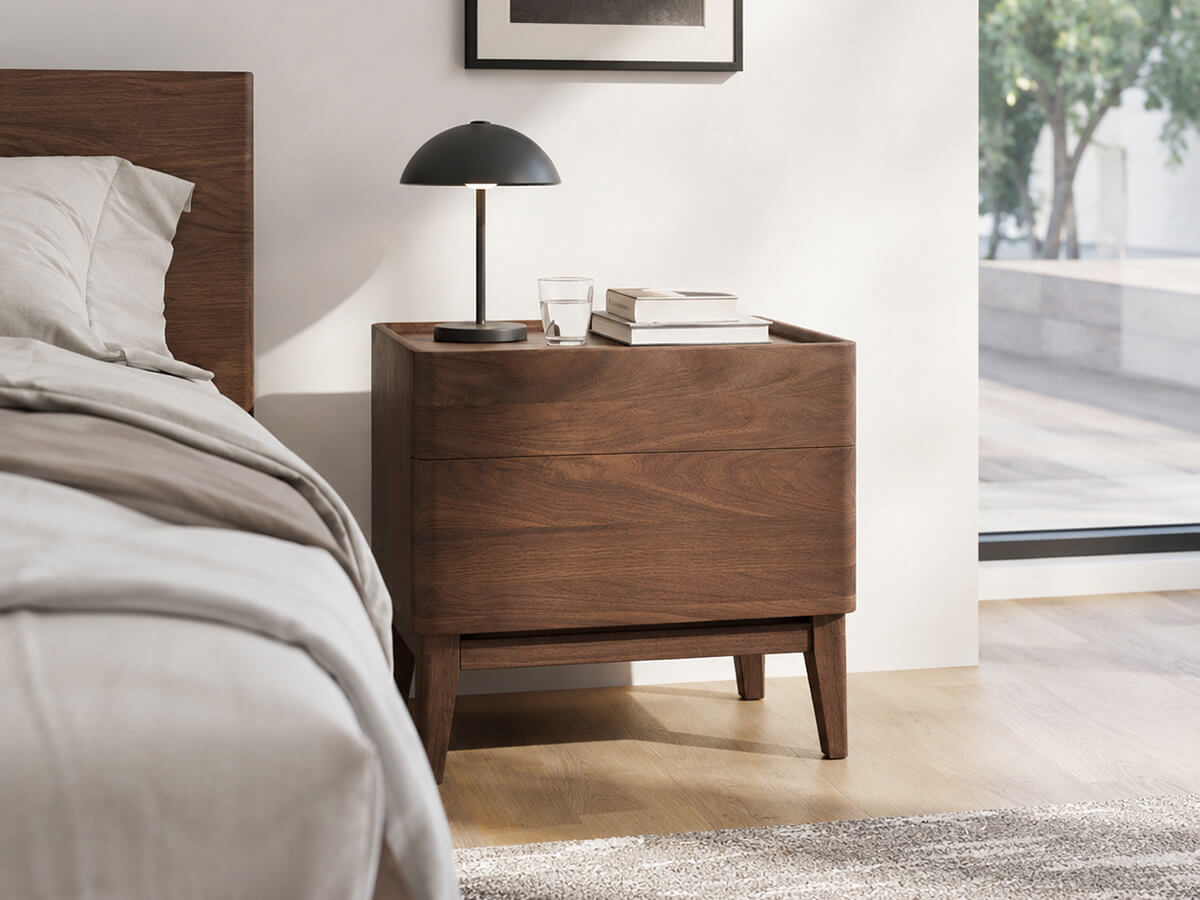 Stanley Solid Walnut Bedside Table beside upholstered bed