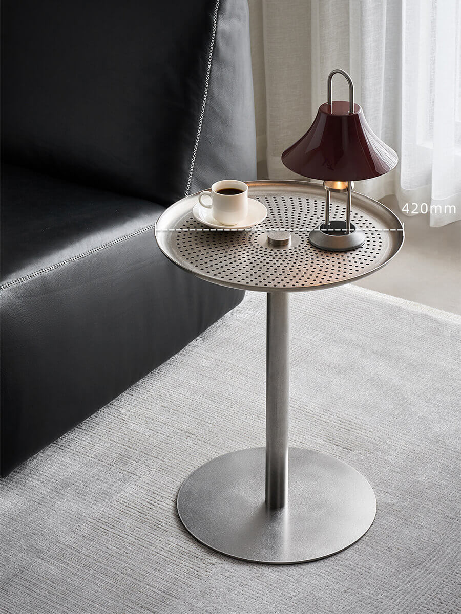 Sterling brushed stainless steel side table beside a black leather chair