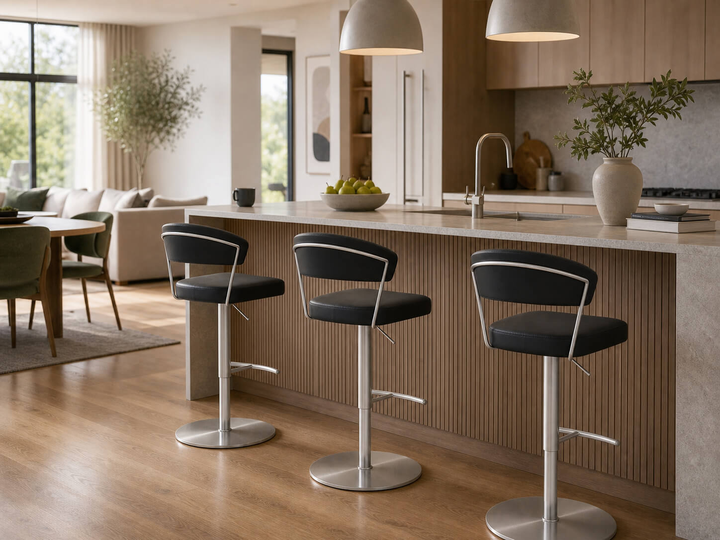 Three Terri black gas lift swivel bar stools with silver bases styled around a modern kitchen island