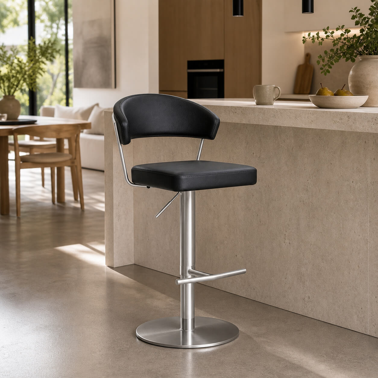 Terri black gas lift swivel bar stool with silver base in a modern kitchen island setting