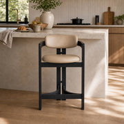 Tritt Bar Stool with black timber frame and beige upholstered seat in modern kitchen