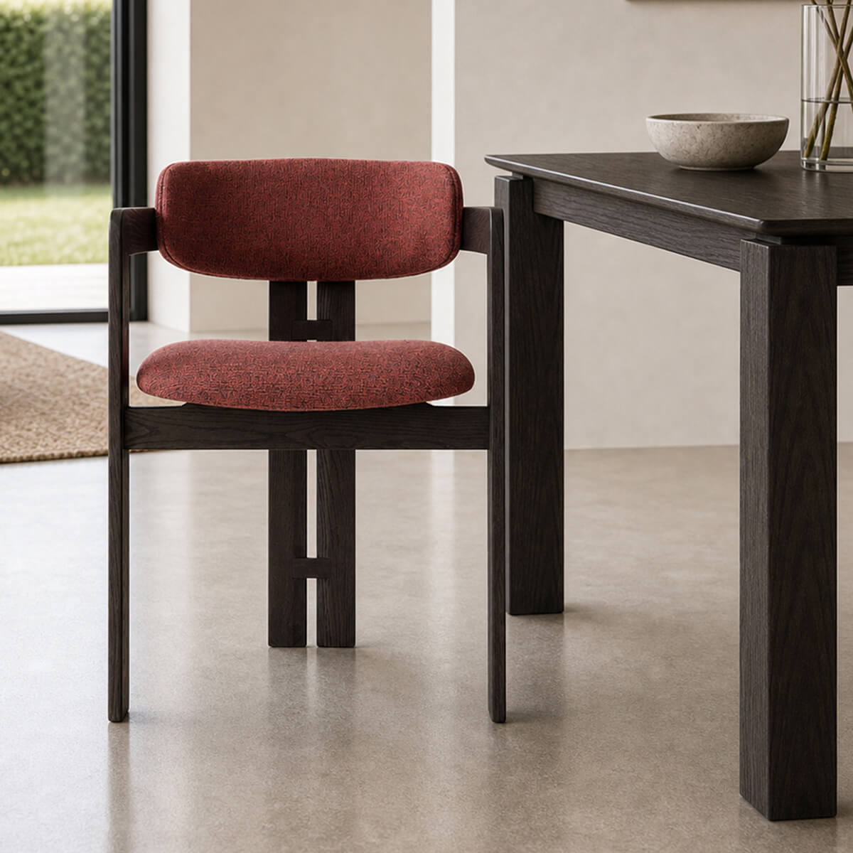 Tritt dining chair with black timber frame and red fabric upholstery beside matching dining table