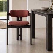 Tritt dining chair with black timber frame and red fabric upholstery beside matching dining table
