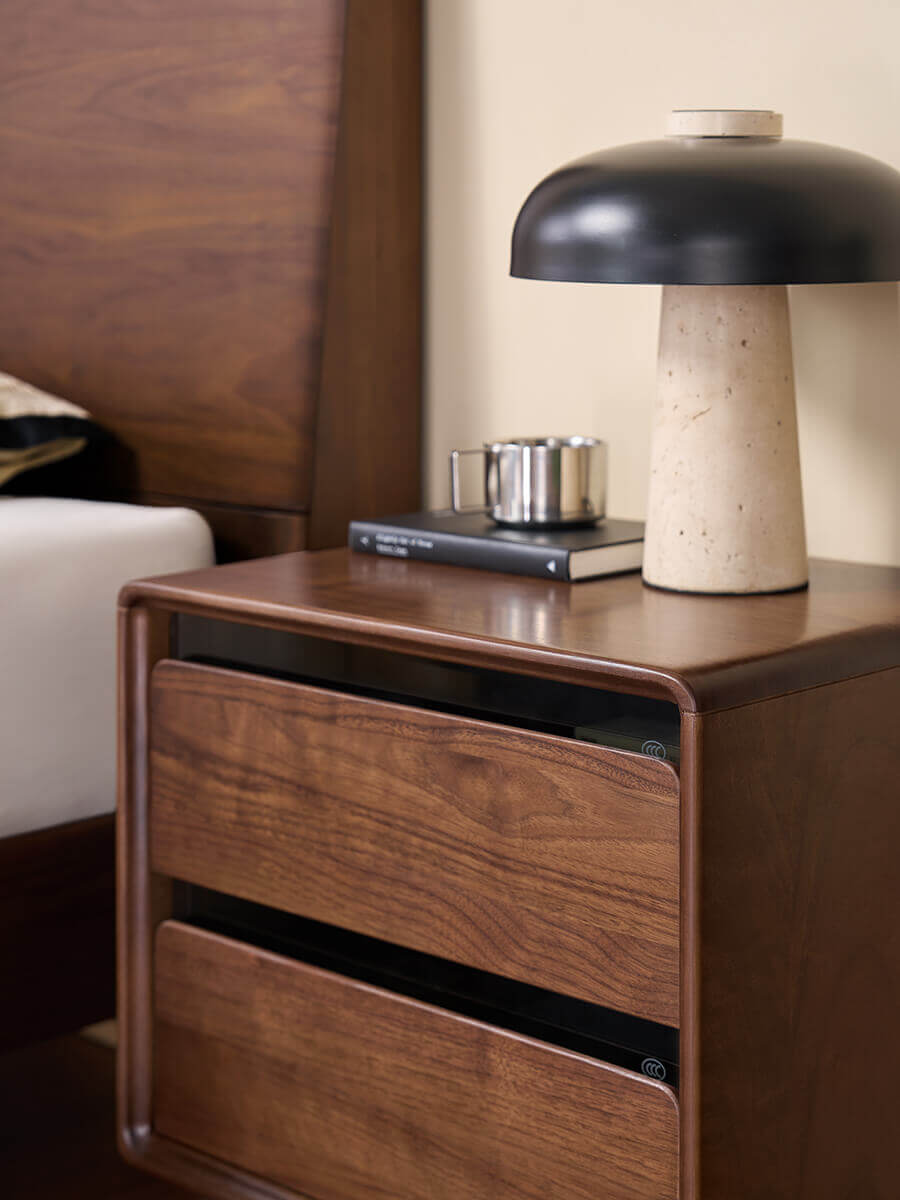 Close-up of the Tura solid walnut bedside table with tempered smoked glass accents
