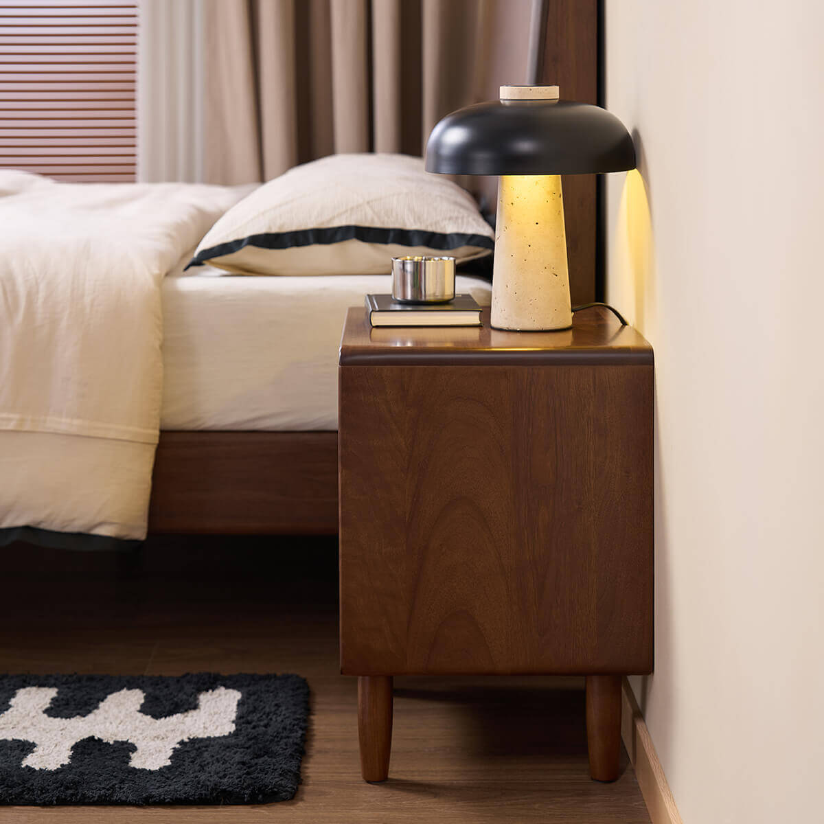 Side view of the Tura solid walnut bedside table highlighting the rounded frame
