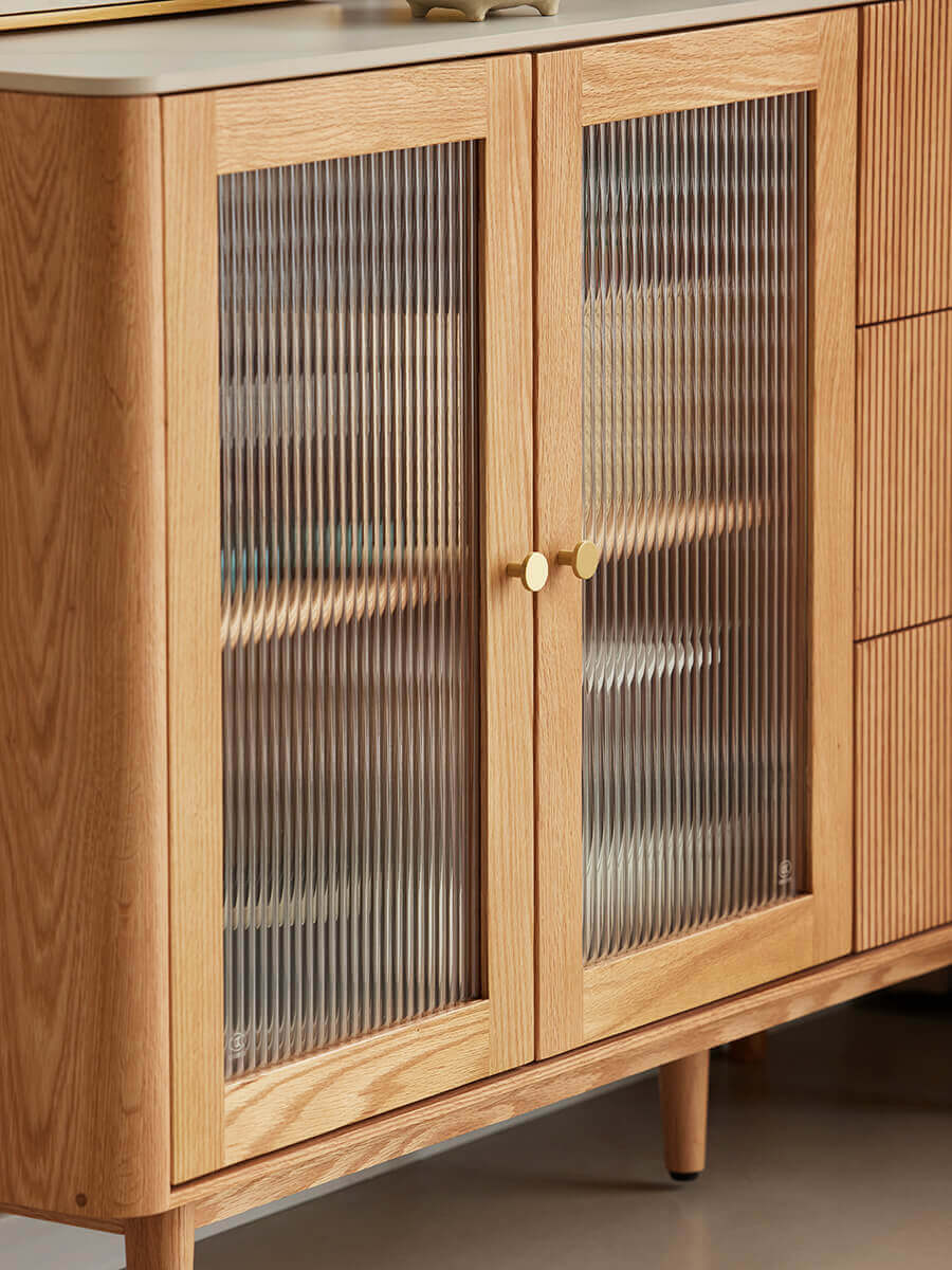 Close-up of Voss solid oak sideboard with reeded glass doors and brass handles.