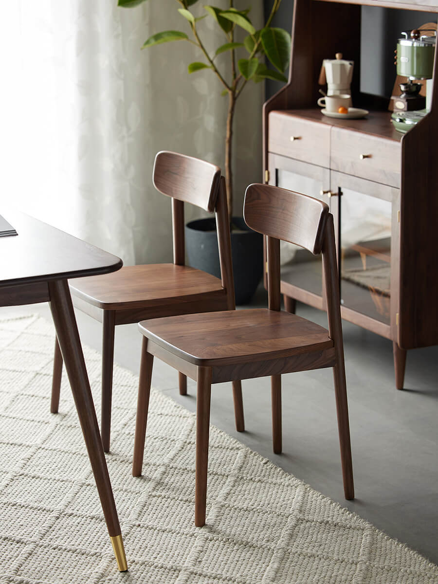 Pair of Bond solid walnut dining chairs in a dining setting