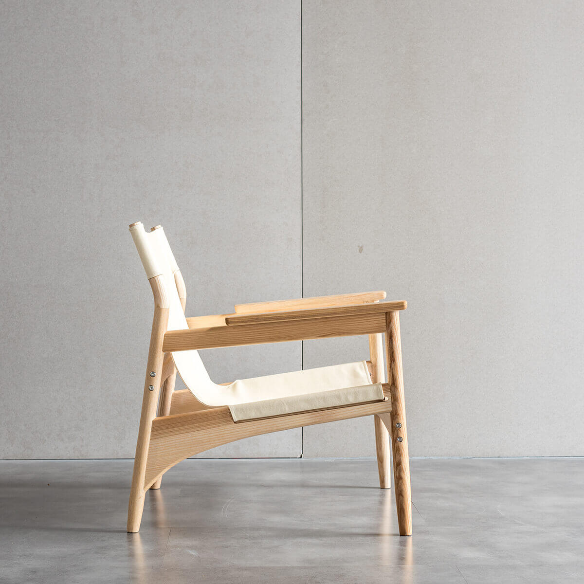 Carey armchair with natural ash timber frame and canvas sling seat side view