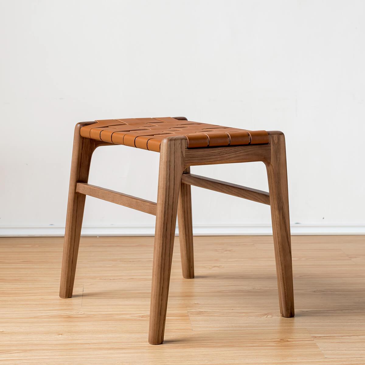 Angled view of the Connar saddle leather stool with solid ash frame
