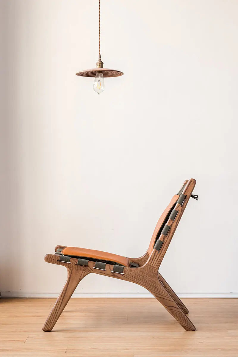 Side view of the Julian Armchair showing its reclined seating angle and woven canvas structure