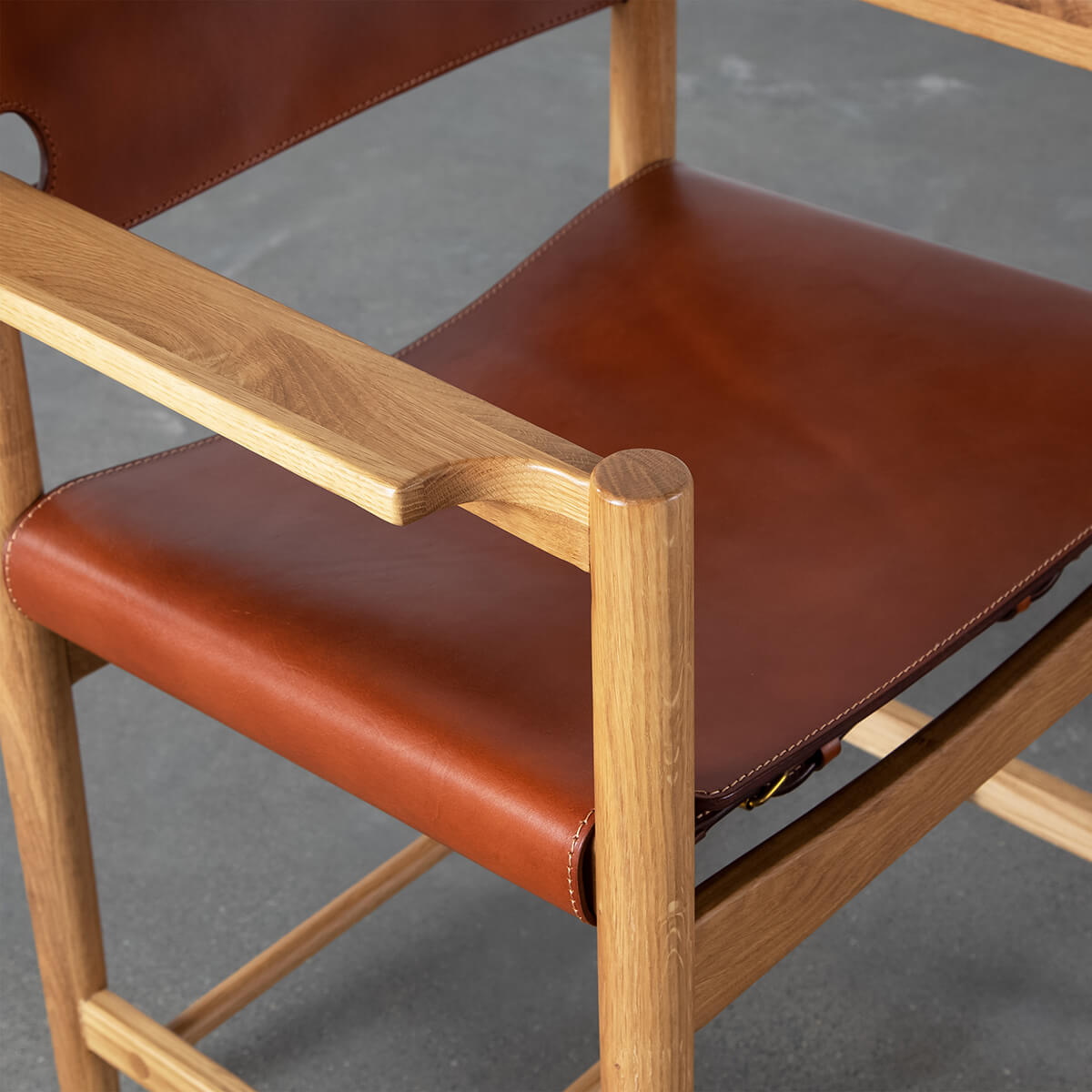 Saddle leather seat and solid American ash armrest detail